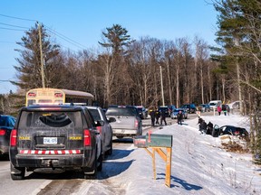 Ontario Provincial Police officers assist passengers and assess the situation at the scene of the collision on Calabogie Road, west of Ottawa, on Friday afternoon.