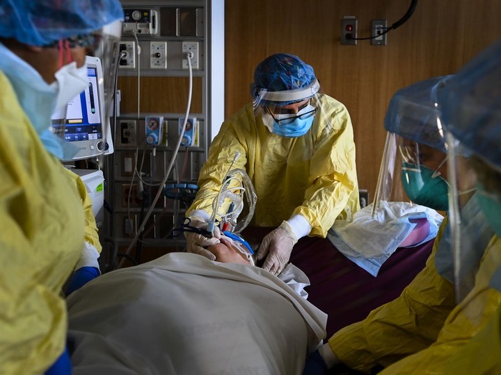  FILE: Health-care workers get ready to turn a COVID-19 patient in the ICU who is intubated and on a ventilator from her back to her stomach at the Humber River Hospital during the COVID-19 pandemic in Toronto on Wednesday, December 9, 2020.