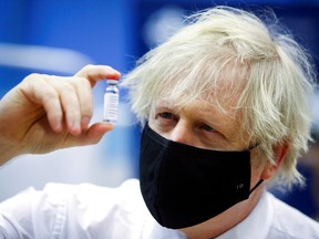 FILE PHOTO: Britain's Prime Minister Boris Johnson holds a vial of an Oxford-AstraZeneca COVID-19 vaccine, during his visit at a vaccination centre at Cwmbran Stadium in Cwmbran, south Wales, Britain February 17, 2021.