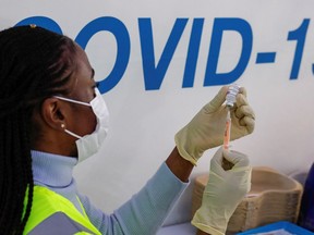 A dose of AstraZeneca vaccine is prepared at COVID-19 vaccination centre in the Odeon Luxe Cinema in Maidstone, Britain February 10, 2021.