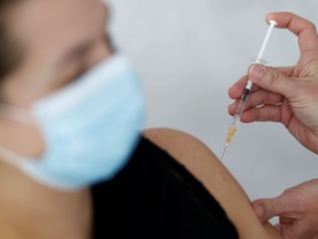 A nurse administers the Oxford-AstraZeneca COVID-19 vaccine to a member of the medical staff at a coronavirus disease (COVID-19) vaccination center in La Baule, France, February 17, 2021.