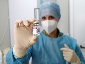 FILE: A medical worker holds a vial of the Oxford-AstraZeneca vaccine.