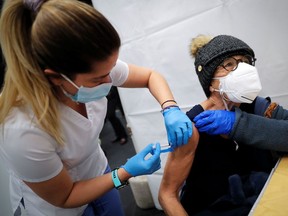 A healthcare worker administers a shot of the Moderna COVID-19 Vaccine to a woman at a pop-up vaccination site operated by SOMOS Community Care during the coronavirus disease (COVID-19) pandemic in Manhattan in New York City, New York, U.S., January 29, 2021.