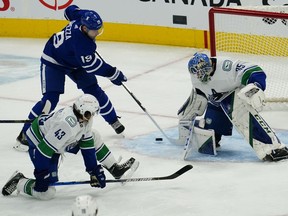 Toronto Maple Leafs forward Jason Spezza (19) shoots the puck on Vancouver Canucks goaltender Thatcher Demko (35) as defenseman Quinn Hughes (43) looks on during the second period at Scotiabank Arena.