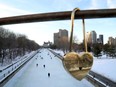Skaters take to the Rideau Canal Skateway behind one of the "locks of love" placed on the Corktown Bridge on a mild February day in Ottawa.
