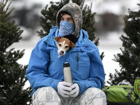 Andy S. keeps his dog Stella warm inside his jacket at a rest stop along the Rideau Canal Skateway.