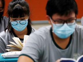FILE PHOTO: Students wear protective face masks.