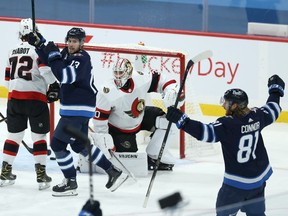 Winnipeg Jets centre Pierre-Luc Dubois (13) and Kyle Connor (81) celebrate a goal from Dylan DeMelo (not shown) against the Ottawa Senators in Winnipeg on Thurs., Feb. 11, 2021.