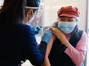 OTTAWA — Margaret Nicholson receives her first dose of the Pfizer COVID-19 vaccine from a nurse at the Wabano Centre for Aboriginal Health, in partnership with Ottawa Public Health, during a vaccination clinic in Ottawa on Feb. 18. Another group of Ottawa residents, including people over 80 in some neighbourhoods, will be eligible for the vaccine at clinics later this week.