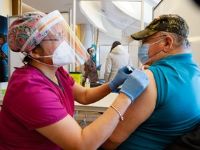 Greg Colbourne receives his first dose of the Pfizer COVID-19 vaccine from nurse Angelita Angeles at the Wabano Centre for Aboriginal Health, earlier this year.