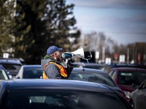 Ottawa city staff outside Nepean Sportsplex announced over megaphones the time slots for vaccinations so people could safely and warmly wait in their vehicles until their turn came up.