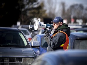 File: City workers direct Ottawa residents at a vaccination clinic