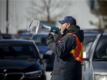 Ottawa city staff were announcing over megaphones, time slots for vaccinations so people could safely and warmly wait in their vehicles until their turn became available for their COVID-19 vaccine at the Nepean Sportsplex on  Sunday.
