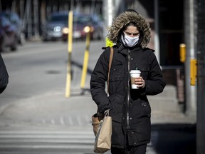 People walk down Bank street in the sunny, but chilly temperatures, Sunday, March 14, 2021.