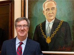 Mayor Jim Watson stands beside a portrait of former mayor Stanley Lewis.