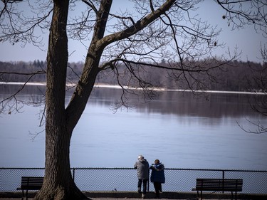 A couple looks out over the Ottawa River at Bate Island on the first weekend of spring, Sunday, March 21, 2021.