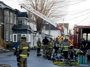 Brockville firefighters confer as they prepare to leave the scene of a fire on Buell Street on Thursday morning,