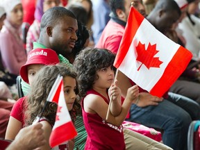 Kids wave the flag as new Canadians take the Citizenship Oath during a special Canada Day ceremony at the Canadian Museum of History in Gatineau. We should treasure our multicultural communities, says Bernard Shinder.