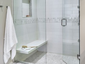 A shower with a rain showerhead, bench and niche is a focal point of this bathroom by Kate + Co Design Inc.