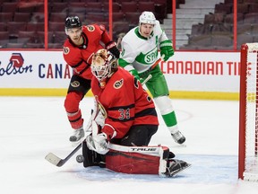 Joey Daccord of the Ottawa Senators makes a save as Artem Zub of the Ottawa Senators and Zach Hyman of the Toronto Maple Leafs look on at Canadian Tire Centre on March 14, 2021 in Ottawa, Ontario, Canada.