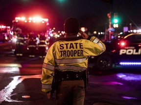 BOULDER, CO - MARCH 22: A Colorado State Police officer salutes as a procession carrying the body of a fellow officer leaves King Sooper's grocery store where a gunman opened fire on March 22, 2021 in Boulder, Colorado. Ten people, including the police officer, were killed in the attack.
