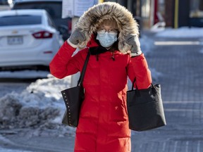 Pedestrian masked up due to COVID, and bundled up due to bitter cold while walking in the west end.