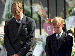 This file photo taken on September 6, 1997, shows Prince William (left) and Prince Harry (right), the sons of Diana, Princess of Wales, bowing their heads as their mother's coffin is taken out of Westminster Abbey, following her funeral service.