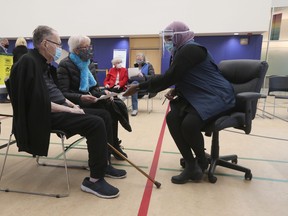Seniors wait to receive their vaccinations from Ottawa Public Health at the The Albion-Heatherington Recreation Centre in Ottawa earlier this month.