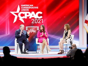 Former Arkansas Governor Mike Huckabee appears on stage with his daughter former White House Secretary Sarah Huckabee Sanders and former White House Director of Strategic Communications Mercedes Schlapp during the Reagan dinner at the Conservative Political Action Conference (CPAC) in Orlando, Florida, U.S. February 27, 2021.