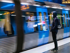 FILE: A commuter wearing a protective face mask waits for the metro at Stockholm's central station on December 3, 2020.