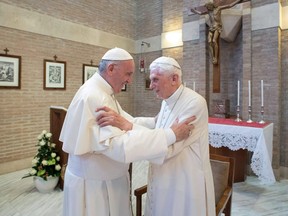 (FILES) This handout picture released on February 15, 2018 by the Vatican press office shows Pope Francis (L) greeting Pope Benedict XVI at the Vatican.