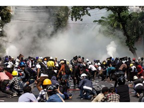 Police fire tear gas into a crowd protesting the military coup in Mandalay on March 3.