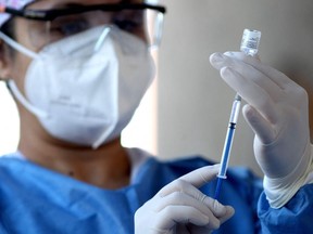 FILE: A nurse prepares a dose of the Pfizer-BioNTech vaccine.