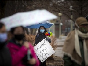 Tong Zhao-Ansari, holding a spread love not hate sign, was at the vigil that was held in Minto Park on Sunday, March 28, 2021.