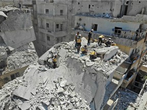 Members of the Syrian Civil Defence (White Helmets) search for victims at the site of a reported air strike on the town of Ariha, in the south of Syria's Idlib province on July 27, 2019.