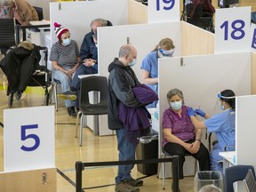 Eligible recipients get their COVID-19 vaccines at a mass vaccination clinic in Toronto on Monday, March 8, 2021.