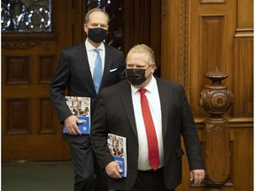 Ontario Finance Minister Peter Bethlenfalvy (left) arrives in the Ontario Legislature with Premier Doug Ford to deliver the Provincial budget March 24.