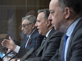 Quebec Premier François Legault, centre, speaks during a news conference on the COVID-19 pandemic on Wednesday at the legislature in Quebec City. Legault is flanked by Horacio Arruda, Quebec director of National Public Health, left, and Health Minister Christian Dubé.