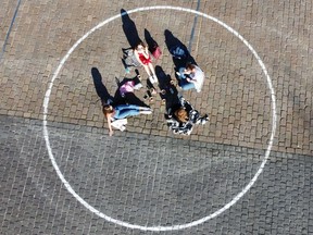 FILE: People relax inside distancing circles.