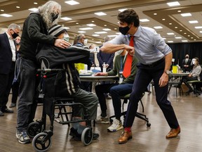 Canada's Prime Minister Justin Trudeau elbow-bumps a patient waiting to get their COVID-19 vaccination at a clinic, as efforts continue to help slow the spread of the coronavirus disease, in Ottawa, Ontario, Canada March 30,