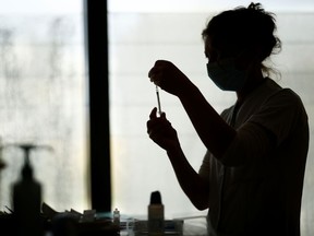 FILE: A healthcare worker prepares a dose of the Pfizer-BioNTech COVID-19 vaccine.