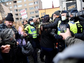 Swedish police break up a demonstration of coronavirus restrictions opponents protesting against a ban on large gatherings, in Stockholm, Sweden on Saturday.