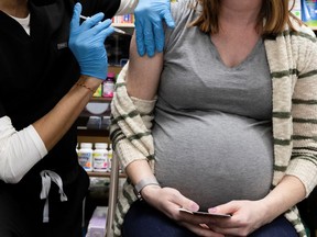 A pregnant woman receives a vaccine for the coronavirus disease (COVID-19) at Skippack Pharmacy in Schwenksville, Pennsylvania, U.S., February 11, 2021.