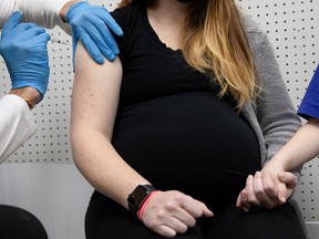 FILE: A pregnant woman receives a vaccine for the coronavirus disease.
