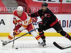 Calgary Flames left wing Matthew Tkachuk (left) controls the puck against Ottawa Senators defenceman Artem Zub  at the Canadian Tire Centre, March 1, 2021.