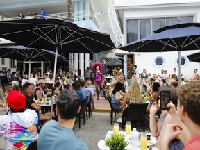 An artist performs at an outdoor restaurant in Miami, Florida, U.S., on Saturday, March 5, 2021. Even with some colleges canceling their mid-semester breaks, students from more than 200 schools are expected to visit Miami Beach during spring break, which runs from late February to mid-April.