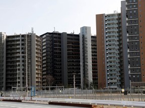 A condo complex in the Athletes Village for the 2020 Olympics is seen behind the fences in Tokyo in a photo taken on March 1.