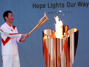 Olympic torch bearer Yoshihide Muroya, Japanese aerobatics pilot and race pilot of the Red Bull Air Race World Championship, reacts as he lights the celebration cauldron at Hibarigahara Festival Site, during the last leg of the first day of the Tokyo 2020 Olympic torch relay, in Minamisoma, Fukushima prefecture, Japan, March 25, 2021.