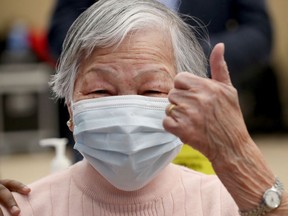 Chui Ping Seto gives the thumbs up after receiving her vaccine from Ottawa Public Health at the The Albion-Heatherington Recreation Centre in Ottawa on Friday, March 5.