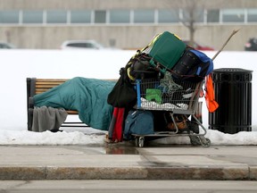 A homeless person huddles on a park bench near the Canadian War Museum last week. The charitable and not-for-profit sectors need to innovate more if they are to continue helping vulnerable people effectively.